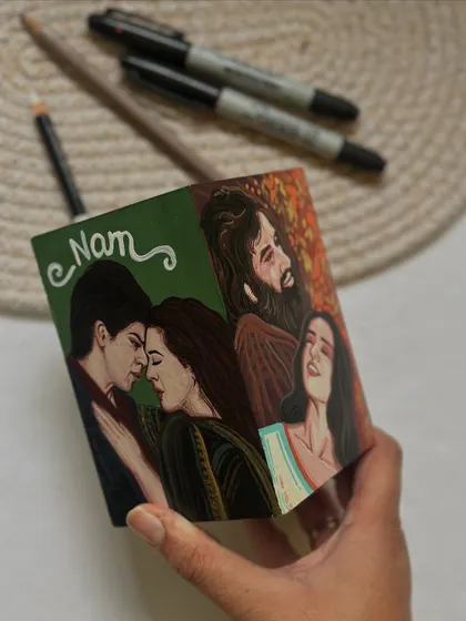Holding the completed four-sided movie pen stand, a perfect personalized gift for a Bollywood fan.