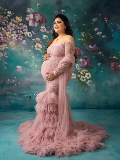 A confident and radiant pose from this beautiful mother. The off shoulder design of the gown and the soft lighting create a truly glamorous maternity photo.