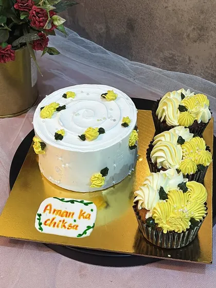 A cute and simple set for a "Chiksa" or Haldi ceremony. This order included a small bento cake and matching cupcakes, all decorated with a cheerful yellow and white theme.