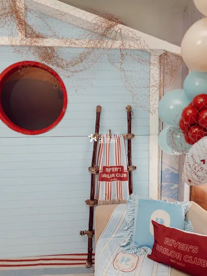 A cozy seating nook with custom-printed pillows and a personalized 'River's Sailor Club' towel.