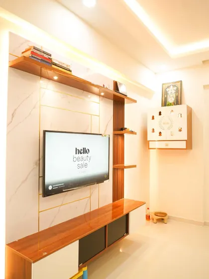 A modern TV unit with a marble-finish back panel, wood accents, and a floating console. The design includes a wall-mounted pooja unit, seamlessly integrating it into the living space.