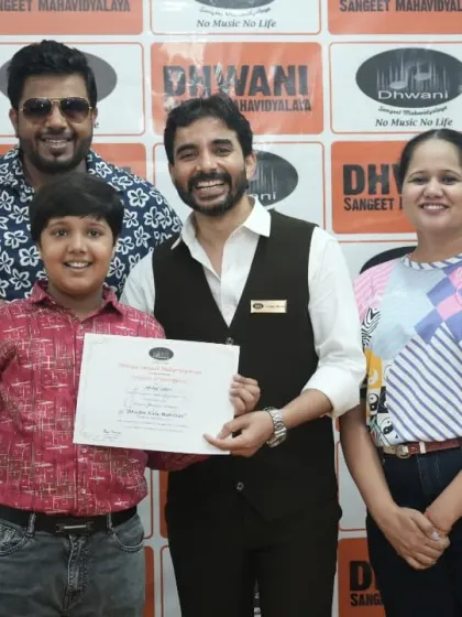 A student, his mother, and his teachers pose with his award.