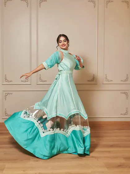 Introducing 'Jasmine', a beautiful indo-western gown in a refreshing teal color. The design features unique sleeves and a sheer panel on the skirt for a modern touch.