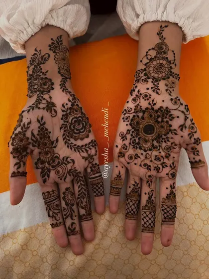 A close-up of the beautiful, asymmetrical design I created for my favorite client. One hand features a floral mandala, while the other has a delicate Arabic vine.