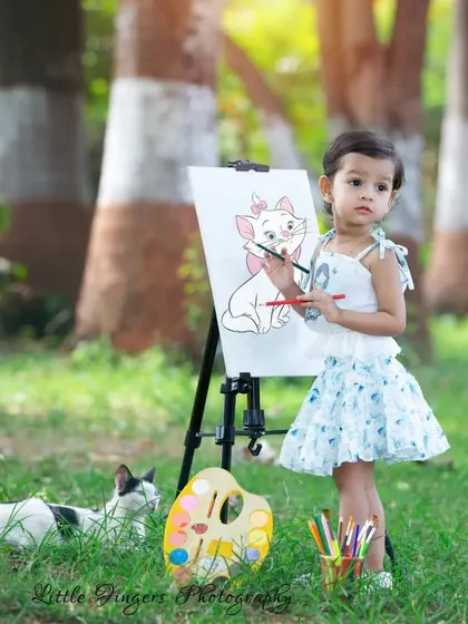 This is what pure, candid joy looks like. I love capturing these unscripted moments, like when a new feline friend decides to join our 'Little Artist' session. It’s these sweet, unexpected interactions that create the most magical childhood portraits.