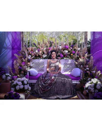 A regal portrait of the bride seated on the beautifully decorated stage at her Mehendi or Sangeet.