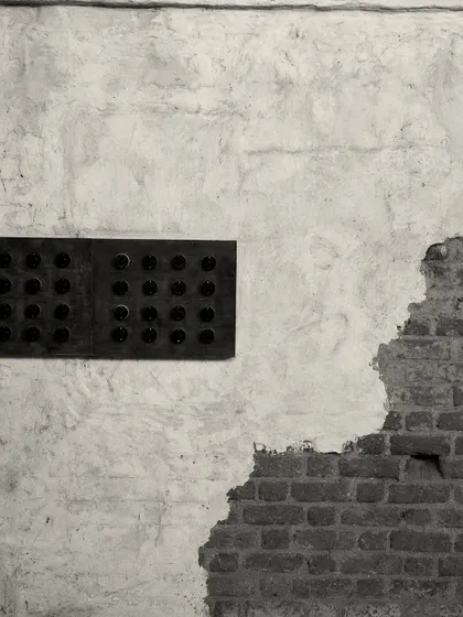 A detail of the wall treatment, where rough, exposed brick meets smooth, aged plaster. This textural contrast is a key element of the "lived-in" aesthetic.