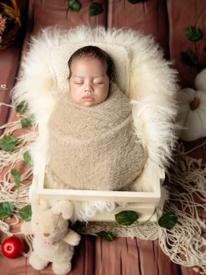 Swaddled snugly in a wooden crate, this baby is dreaming sweet dreams in our woodland-themed setup.