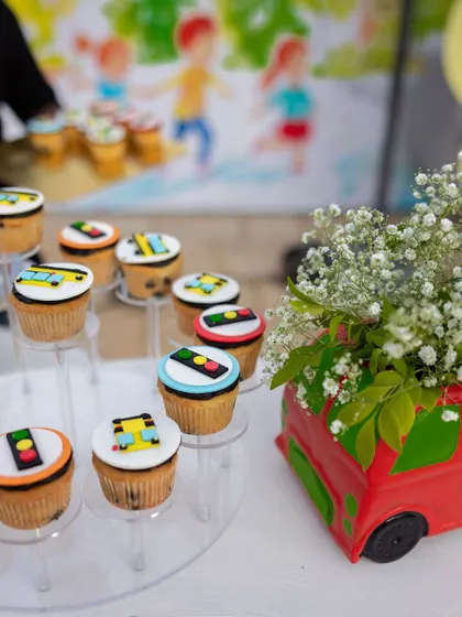 Themed cupcakes for a "Wheels on the Bus" party. The cupcakes are topped with edible traffic light and bus-themed decorations, adding a sweet touch to the transportation theme.