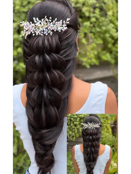 A finished open hairstyle with a beautiful braid and a crystal hair accessory.