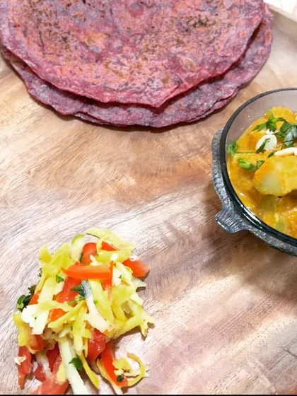 A complete satvic meal on a plate. This features my vibrant beet roti, a creamy bottle gourd curry, a fresh salad, and one of my signature 'Dates Sneaker' for a touch of sweetness.