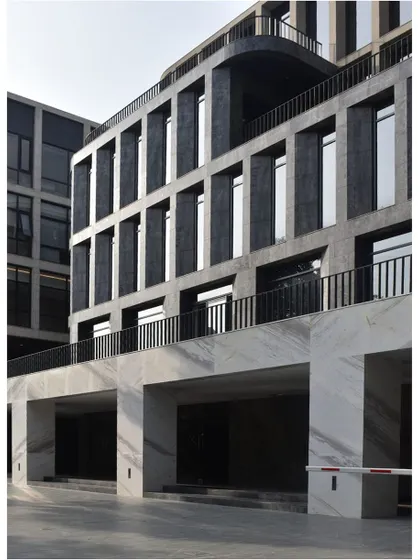 The facade of the '378' office building in Bengaluru, showcasing a powerful composition of dark marble cladding and recessed windows. The design plays with shadow and depth to create a visually dynamic exterior.