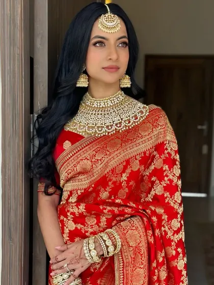 A beautiful bride in a classic red Sabyasachi saree. I styled her hair in soft, open waves for a timeless and royal look.