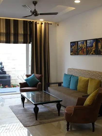 We believe in dissolving the boundaries between inside and out. This living room opens directly onto a tranquil zen garden, where a Buddha statue creates a focal point for contemplation and calm, making the garden an extension of the living space.