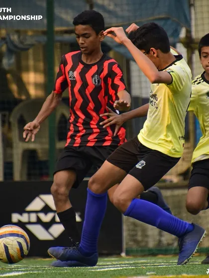 An intense moment from a Youth Championship game, with our player battling for possession against two opponents.