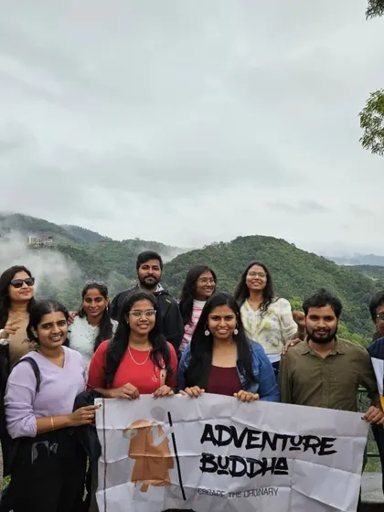 A classic Adventure Buddha group photo from a viewpoint in Coorg. The misty mountains in the background are the perfect setting for making new friends and capturing memories.