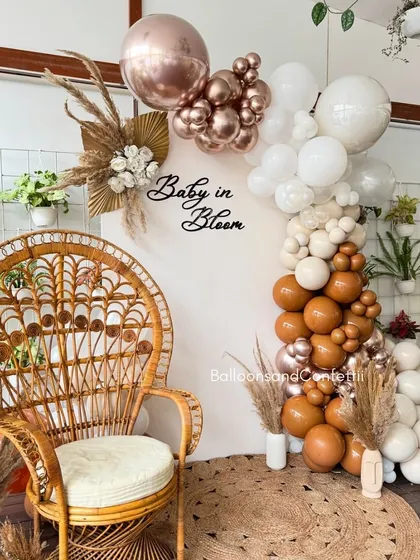 Celebrating a 'Baby in Bloom' with this chic, bohemian-themed baby shower. I used a warm, earthy palette of neutral and rose gold balloons, accented with dried pampas grass. The wicker peacock chair creates a beautiful focal point for the mom-to-be.