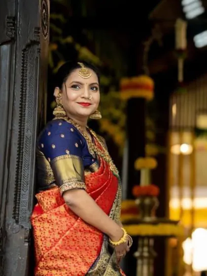 A close-up portrait of Apoorva. The rich colors of her saree and the traditional jewelry highlight her bridal glow.