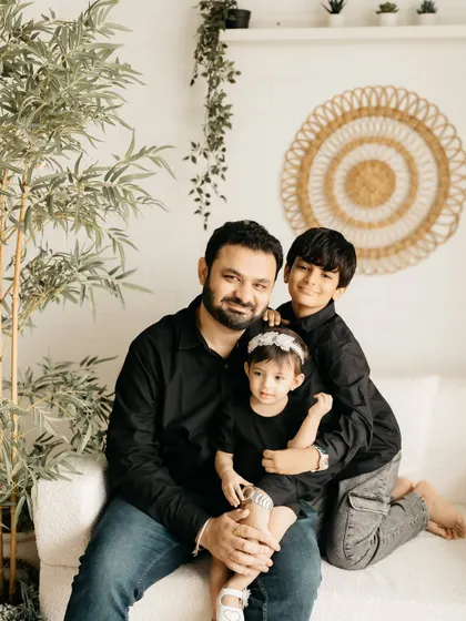 A father with his two children, showing the loving and protective bond in a relaxed studio setting.