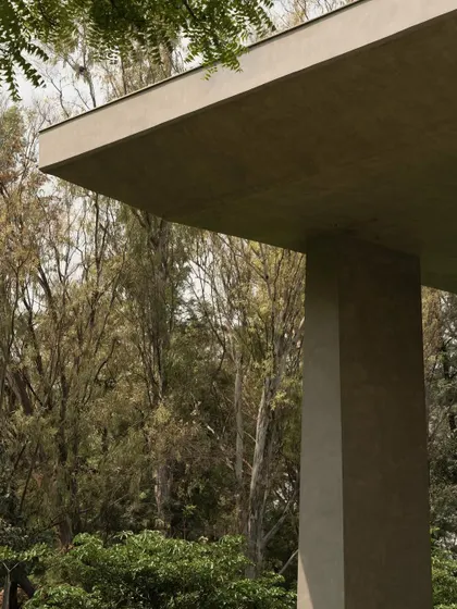 Close-up details of the concrete facade, showing the interplay of sharp angles, deep recesses, and smooth surfaces. These shots emphasize the building's sculptural and tactile qualities.
