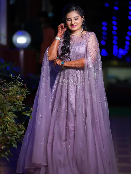 A full-length portrait of the bride in her reception gown. She looks radiant and happy, ready to celebrate the night away.