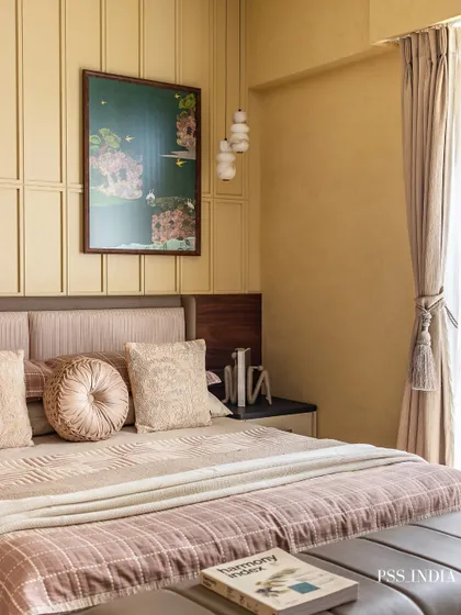 This bedroom is a sanctuary of warmth and comfort. The paneled wall, layered bedding in dusty rose and beige, and a statement art piece come together to create a space that invites you to rest and recharge.