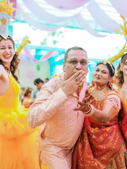 Family members having a blast with dancers at a colorful, carnival-themed wedding event.