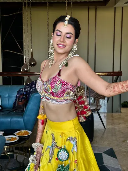 Haldi ready! This look features subtle purple eyes that beautifully complement her vibrant yellow outfit. The makeup is kept fresh and glowing for the daytime event.