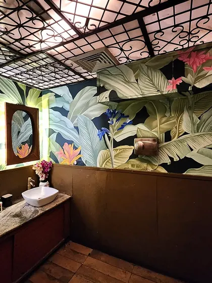 A different angle of the washroom mural, showcasing the variety of tropical plants and flowers we included in the design.