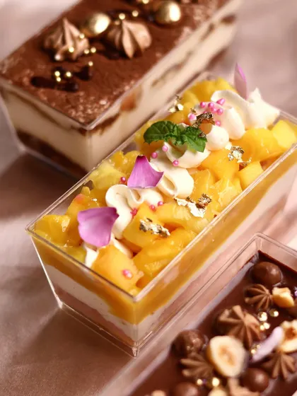 Our mini dessert box for Mother's Day includes a variety of treats, like this beautiful Mango Trifle, decorated with edible flowers and gold leaf.