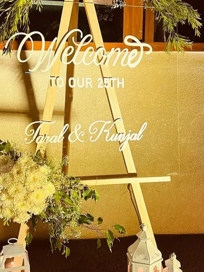 A personalized welcome sign is a small detail that makes a big impact. For this 25th-anniversary event, we created an elegant acrylic sign on a wooden easel, adorned with fresh flowers to greet the guests of honor.