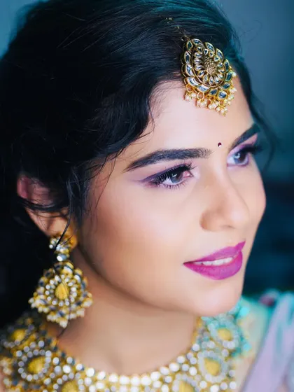 A beautiful profile shot highlighting the shimmery pink eyeshadow and the perfectly blended skin.