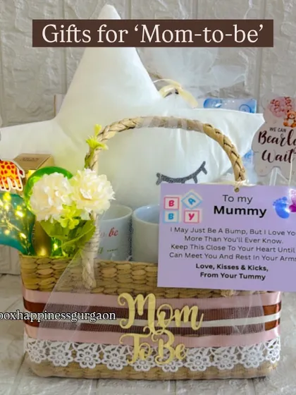 A beautifully arranged "Gifts for Mom-to-be" basket, featuring a star cushion and a sweet note from the baby bump.