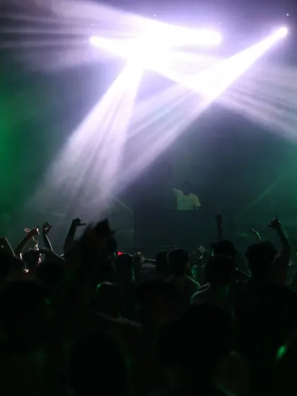 The crowd is fully engaged, with spotlights creating a powerful visual focus on the performance.