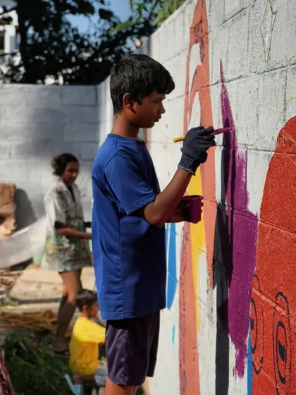 A young boy fully absorbed in adding a rich purple hue to our collaborative mural. It is in these quiet moments of concentration that you see the real connection happening between the artist and the artwork.
