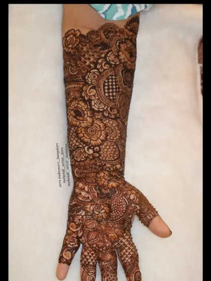 A single arm shot of this floral bridal mehendi, allowing a closer look at the detailed petal and leaf work.