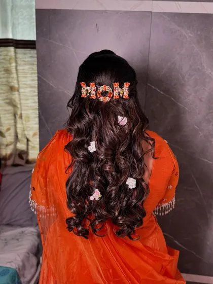 The final look of her beautiful baby shower hairstyle, with soft curls and whimsical accessories.