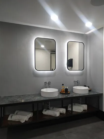 A close-up of the dual vanity in the studio's restroom. The backlighting on the mirrors provides excellent task lighting while adding a touch of sophisticated design to the space.