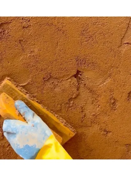 Applying the final coat of 'Thappi' lime plaster. The beauty of this technique lies in its natural, earthy finish and the hands-on process of its creation.