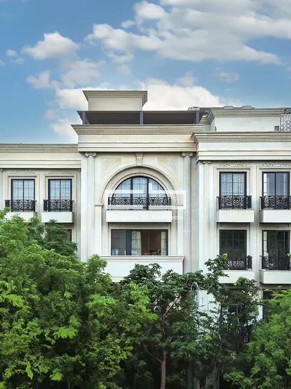 A daytime view of a facade that fuses modern design and classical aesthetics. An arched window adds dynamism to the edgy lines, while the white hues contribute to the classical feel.