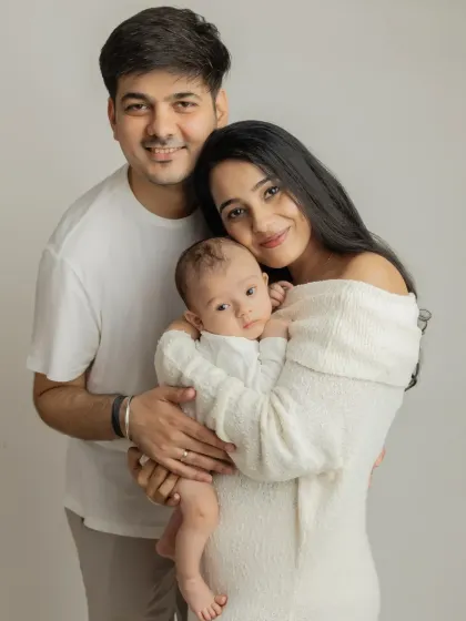 A classic first family portrait. I love the simplicity of the all-white outfits, which keeps the focus on the family's loving connection and their beautiful baby.