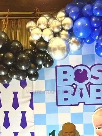 A close-up of the balloon garland for a Boss Baby party, showing the mix of black, royal blue, and metallic silver balloons.