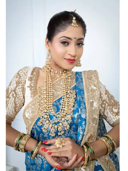 A direct and confident look, showcasing the full beauty of the blue Nauvari and layered jewellery.