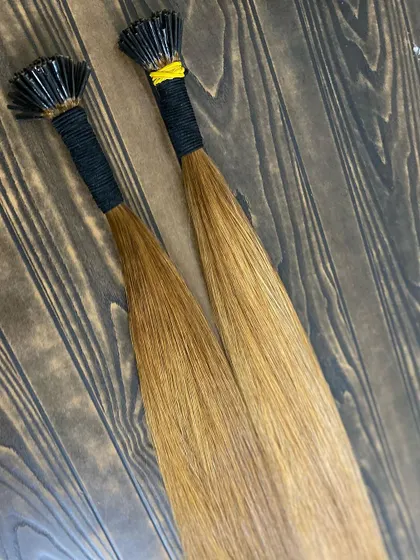 Two bundles of our blonde I-Tip extensions, showcasing their silky straight texture. These are perfect for adding highlights or a full head of blonde, available for bulk orders.