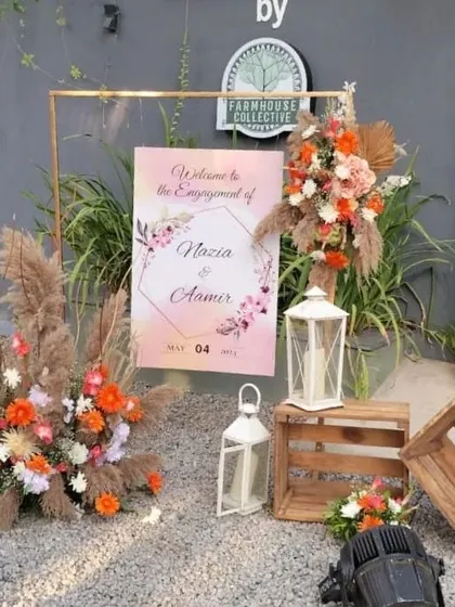 Another view of the engagement welcome setup, showcasing the beautiful contrast between the soft pampas grass and the bright orange flowers.