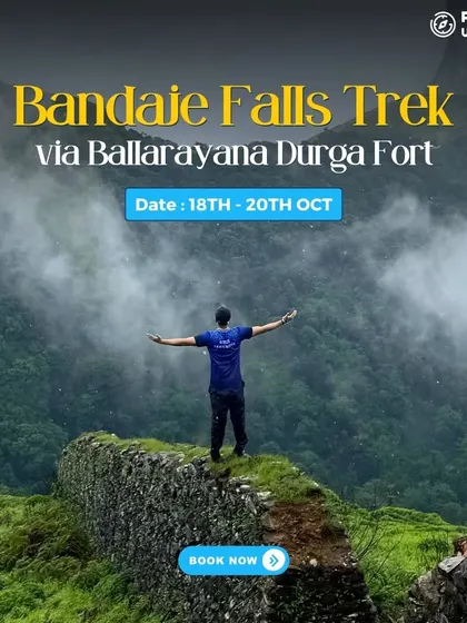 A trekker stands on a fort wall, looking out at the misty mountains on the Bandaje Falls trek.