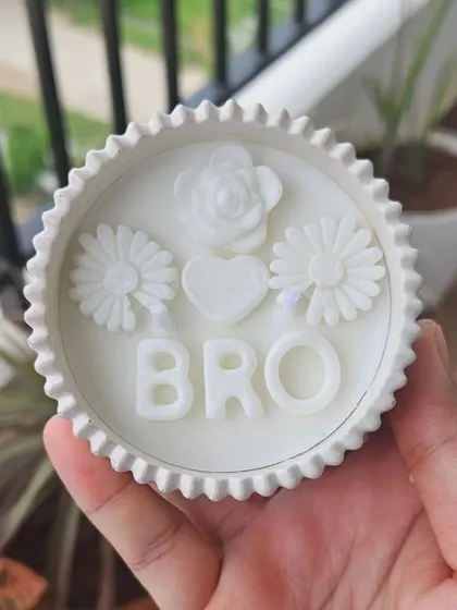 A special Rakhi-themed candle for your 'BRO'. The top is decorated with wax flowers and a heart, making it a unique and personal gift for your brother. You can customize the vessel, color, and scent.
