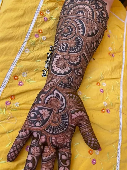 A complete bridal arm and hand design, showcasing a seamless flow of patterns from the fingers to the elbow. The use of paisleys and floral motifs is a timeless choice.