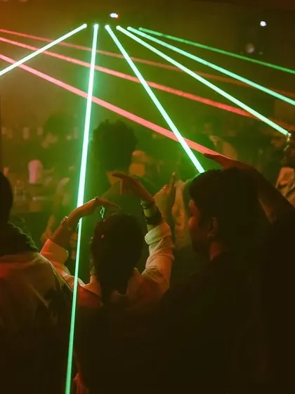 The view from behind the booth, with lasers cutting through the darkness over a packed dance floor. This is the classic techno club experience I love to create.