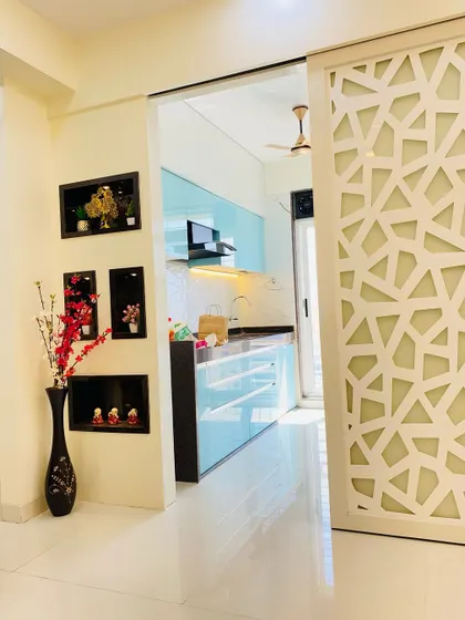 A view from the living room into the kitchen, showing how a sliding jaali partition can be used to either open up the space or provide privacy.